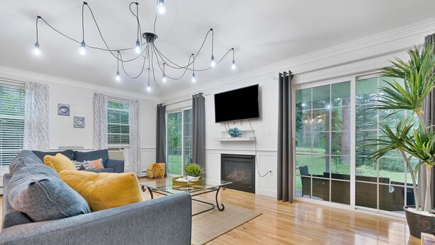 Una sala de estar moderna con chimenea, ventanas amplias y televisor de pantalla plana.