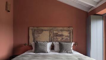 A bed with a rustic headboard, two pillows, and a textured blanket.