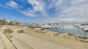 A marina with numerous sailboats docked, a stone walkway, and a distant building with a tower. - Port and beaches within walking distance for 6 (Piriac-sur-Mer)
