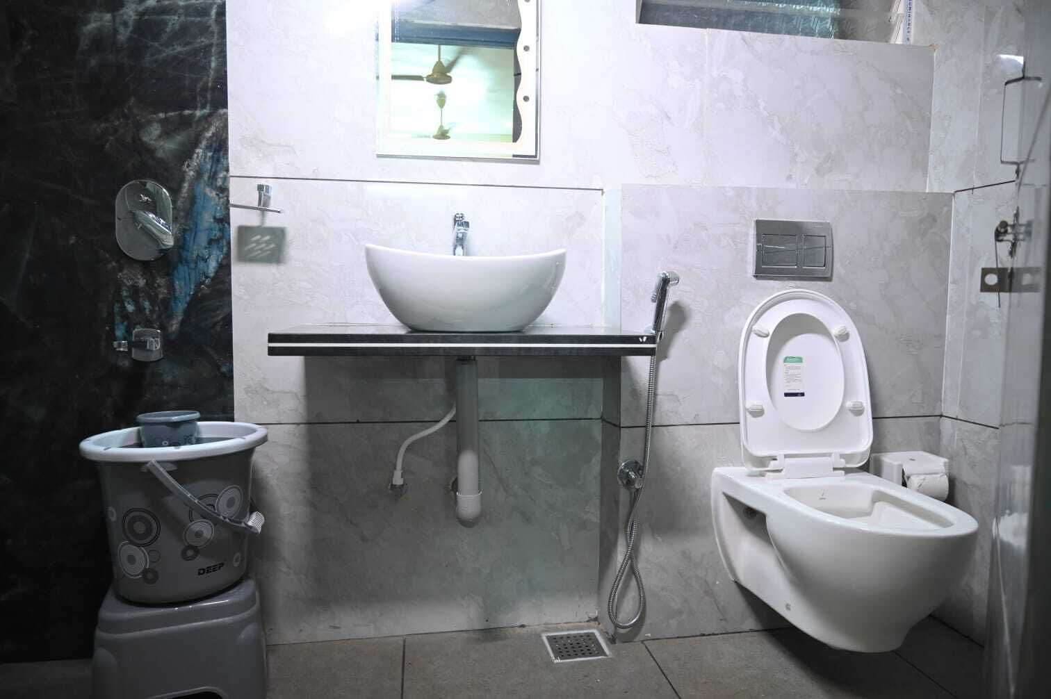 A bathroom with a white sink, a toilet, and a bidet.
