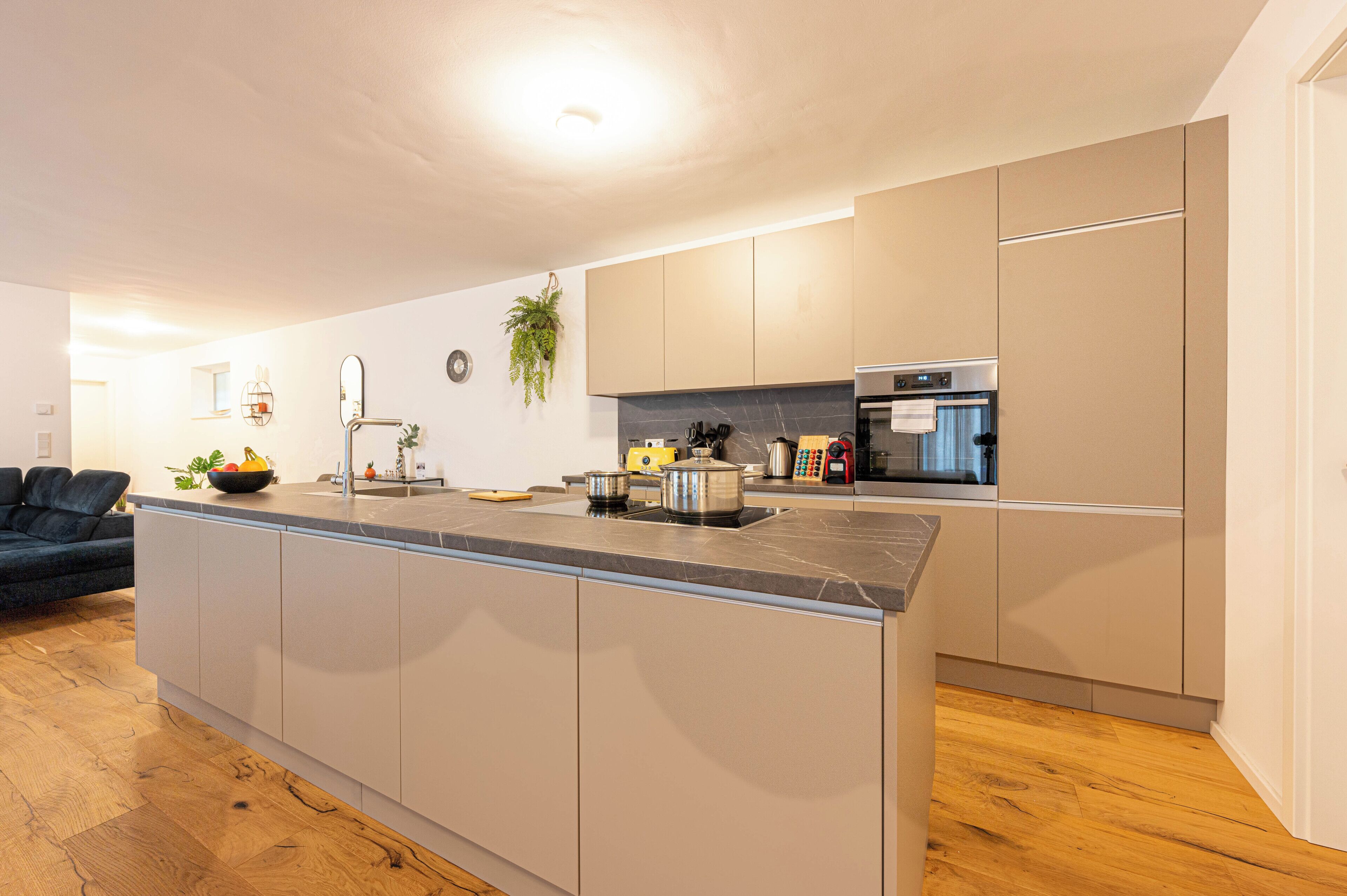 Eine moderne Küche mit Kochinsel, Edelstahlgeräten und minimalistischem Design.