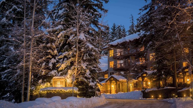 A snow-covered lodge with a sign reading "HORSTMANN LUXURY HOTEL" and a "No Parking" sign.