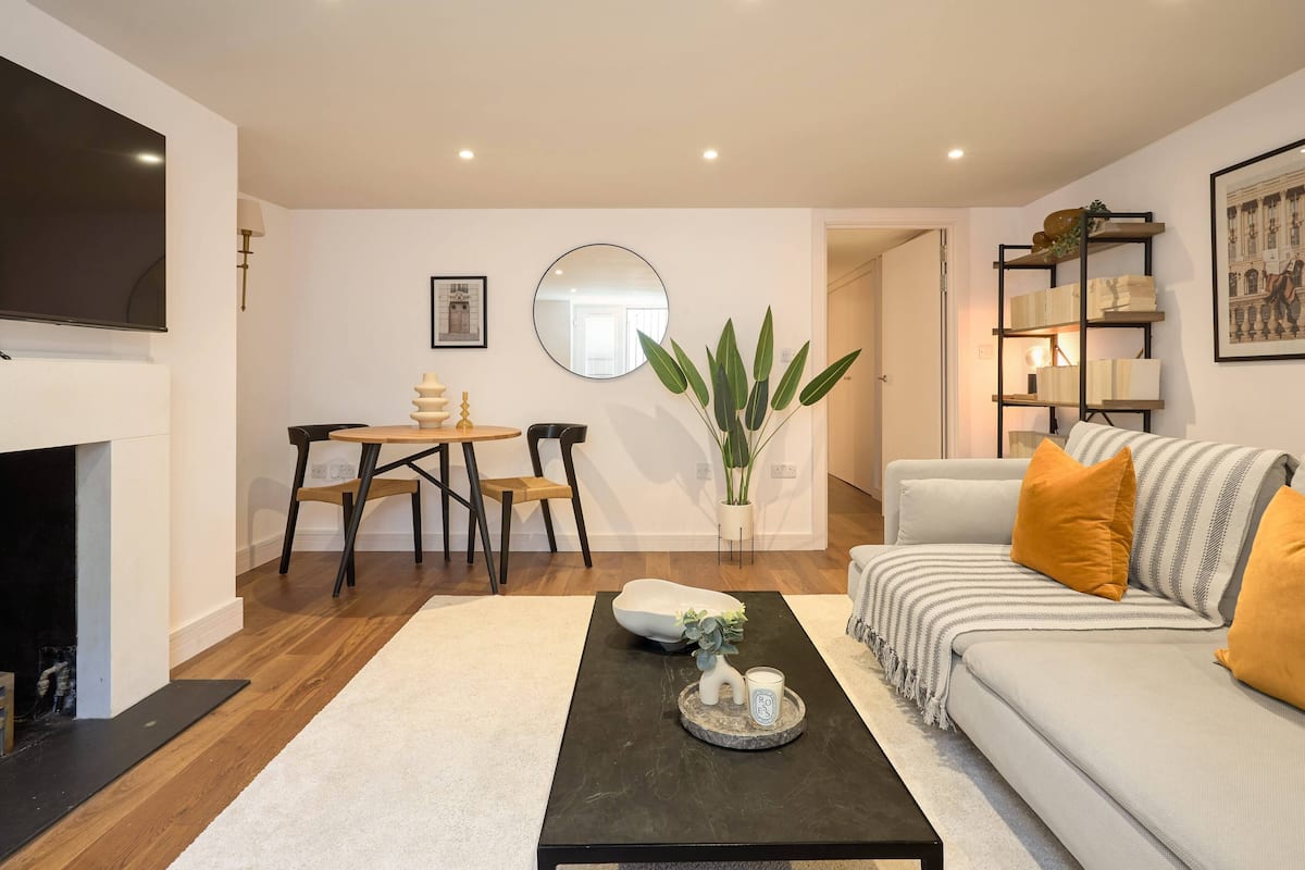 Een moderne woonkamer met een bank, salontafel en een open haard.