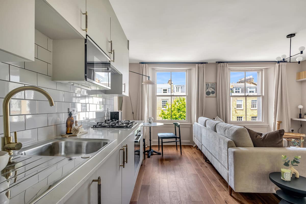 Een moderne keuken met een groot raam, een bank en een eethoek.