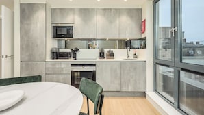 Una cucina moderna con mobili grigi, un forno integrato e un'ampia finestra.