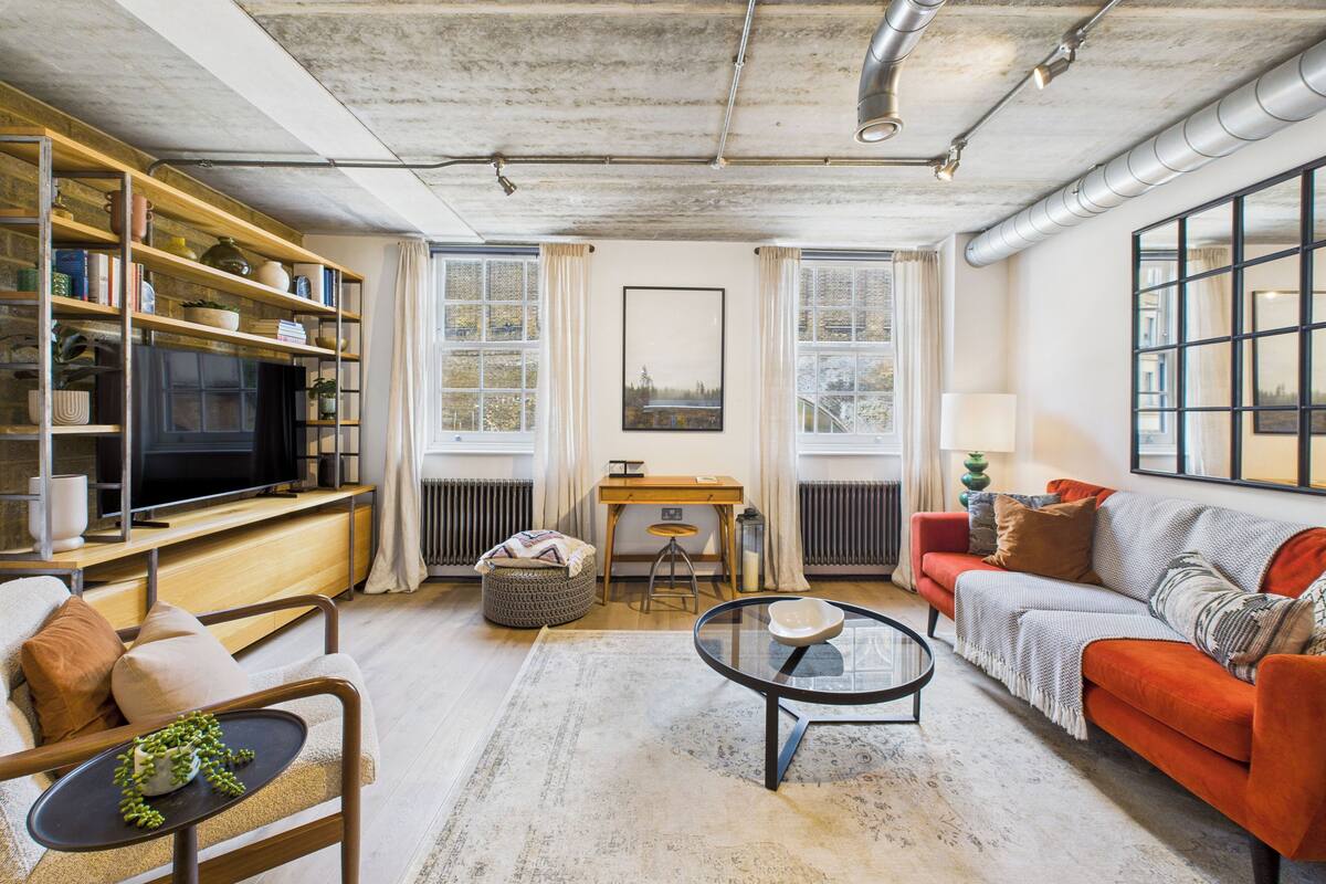 Un salon moderne comprenant un téléviseur, des étagères, un canapé et une table basse.