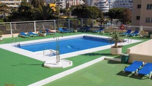 A rooftop swimming pool with blue lounge chairs and a diving board. - Estepona Marina Apartment, Costa Del Sol (Estepona)