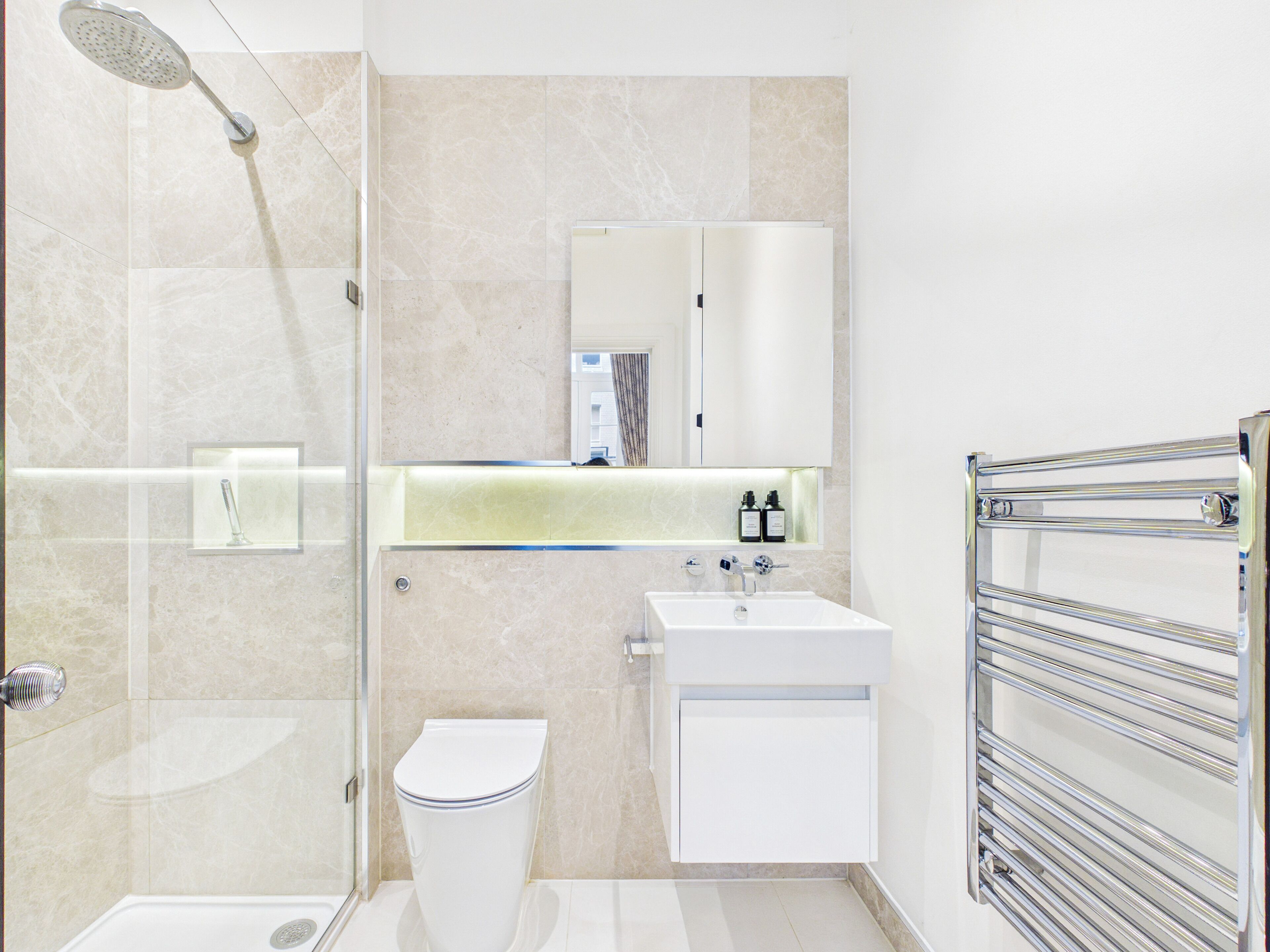 A modern bathroom with a shower, toilet, sink, and a glass-enclosed shower area.