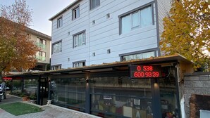 A modern building with a glass storefront and a digital display showing prices. - Deniz Butik Hotel (Tekirdag)