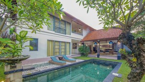 A two-story house with a swimming pool, outdoor seating, and a garden. - Dampati Villas (Denpasar)