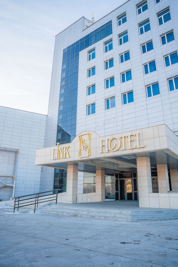 Ein Hotel mit modernem Eingang, großen Fenstern und einer markanten Beschilderung.