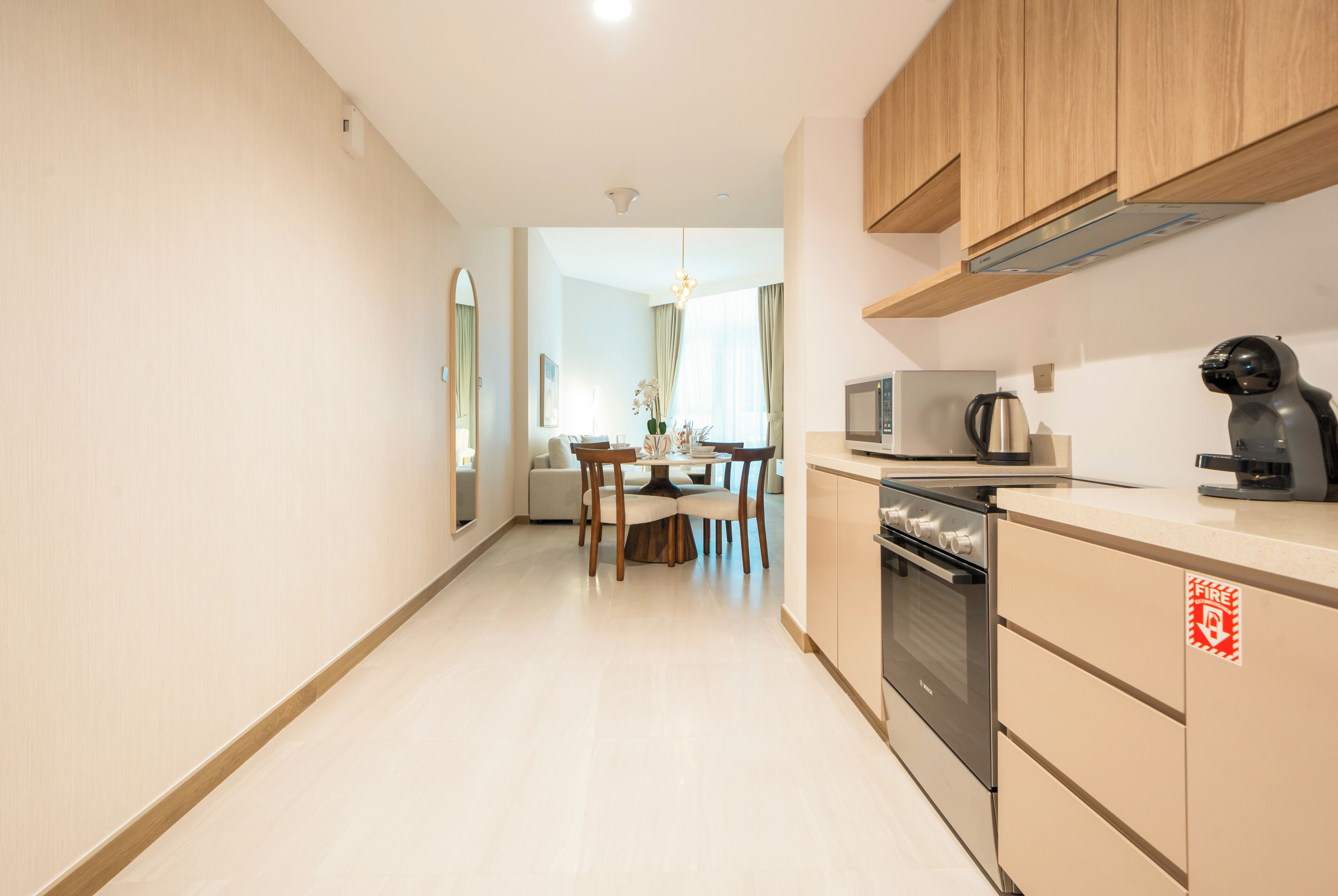 Une cuisine moderne dotée de meubles en bois, d’un four à micro-ondes, d’une machine à café et d’un coin repas avec une table et des chaises.