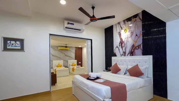 Een moderne hotelkamer met een groot bed, een plafondventilator en een marmeren wand.