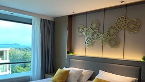 Una habitación de hotel moderna con una cama grande, vistas al exterior y un panel decorativo en la pared.
