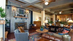 A spacious living room with a fireplace, leather sofas, a coffee table, and a variety of decorative items.