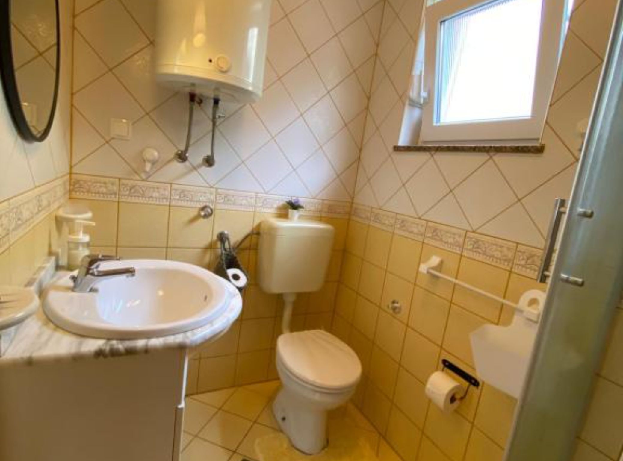 Ein Badezimmer mit Waschbecken, Toilette und Fenster.