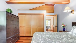 Un dormitorio con una cama, un armario de madera y una mesita de noche con lámpara.