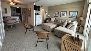 A compact living space with a kitchenette, a dining area, and a seating area with a sofa and chairs.