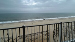 A beach with a metal railing in the foreground.