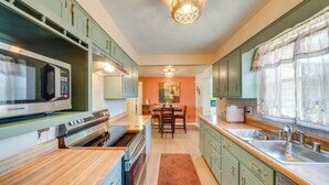 A kitchen with green cabinets, a stainless steel stove, and a microwave. - 11 Mi to Uofl & Norton Hospital: Louisville Home (Louisville)