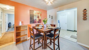 A dining area with a wooden table and chairs, a vase with flowers, and a painting on the wall. - 11 Mi to Uofl & Norton Hospital: Louisville Home (Louisville)