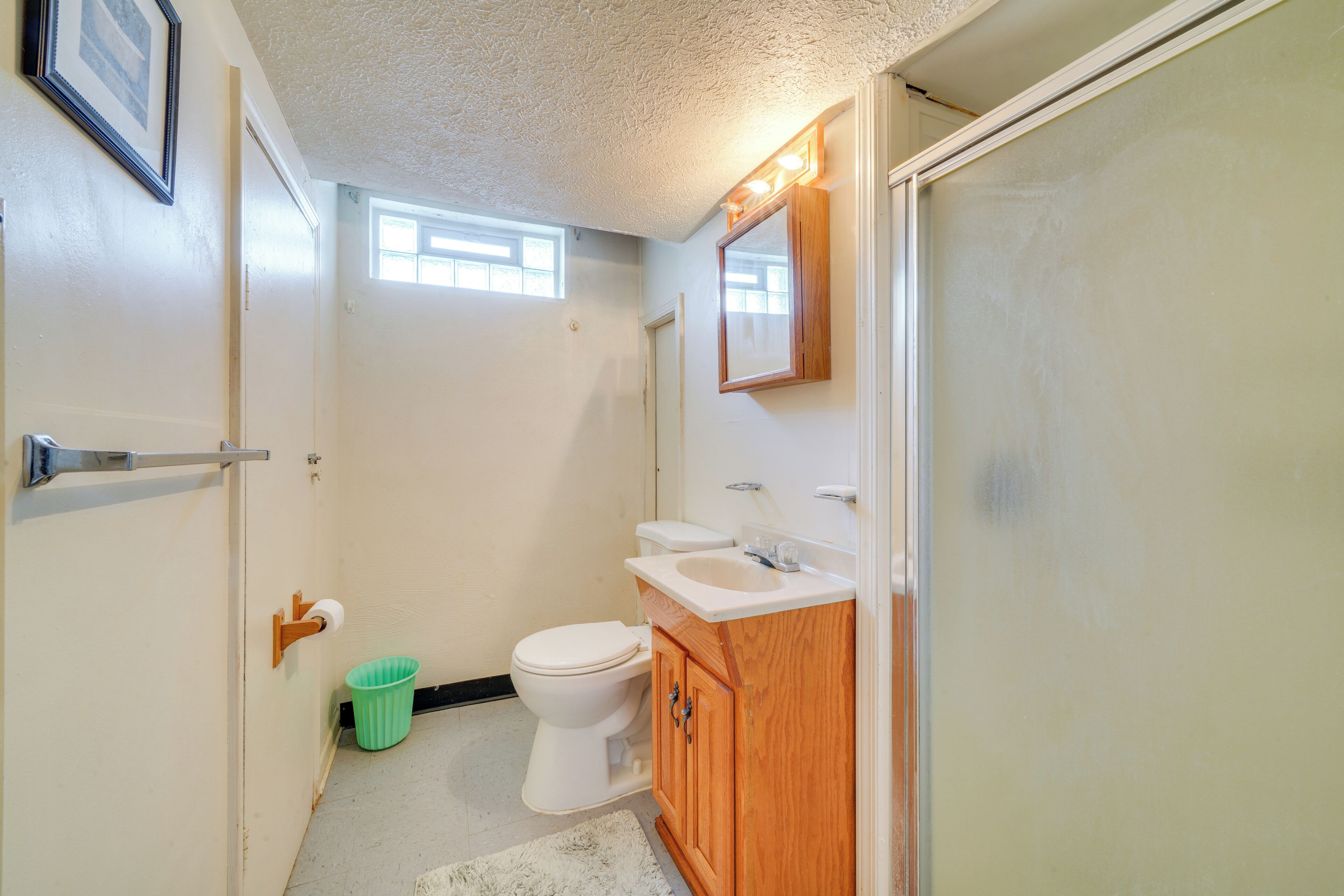 A small bathroom with a toilet, sink, and mirror.