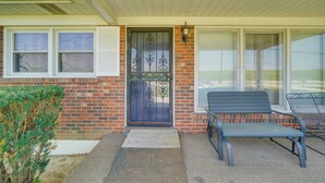 A front porch with a metal gate, a bench, and a small garden area. - 11 Mi to Uofl & Norton Hospital: Louisville Home (Louisville)