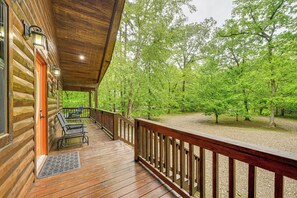 A wooden deck with a railing, a door, and two chairs. - Private Hot Tub & Deck: Woodsy Broken Bow Retreat (Broken Bow)