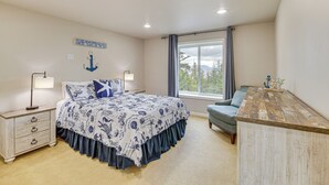 Een slaapkamer met een bed, nachtkastjes, een dressoir en een raam met uitzicht.