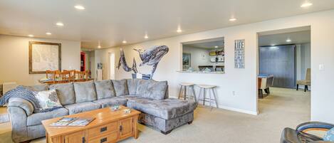 A spacious living room with a sectional sofa, a wooden coffee table, and a leather chair.