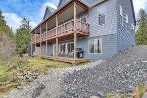 A two-story house with a wooden deck and a barbecue area.