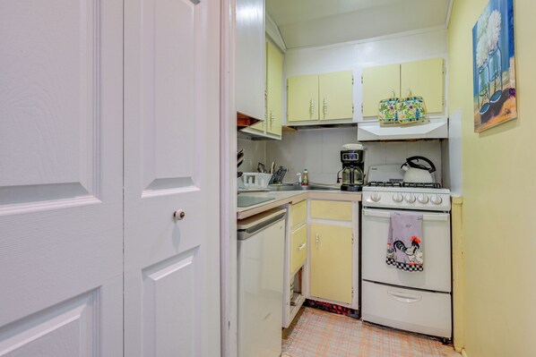 A kitchen with yellow cabinets, a white stove, and a coffee maker. - < 1 Mi to Old Town Lansing: Home w/ Furnished Deck (Lansing)