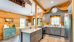 A spacious kitchen with wooden walls, a large island, and modern appliances. - Relax Fireside! Creek Cabin 9 Mi to Dtwn Murphy (Murphy)