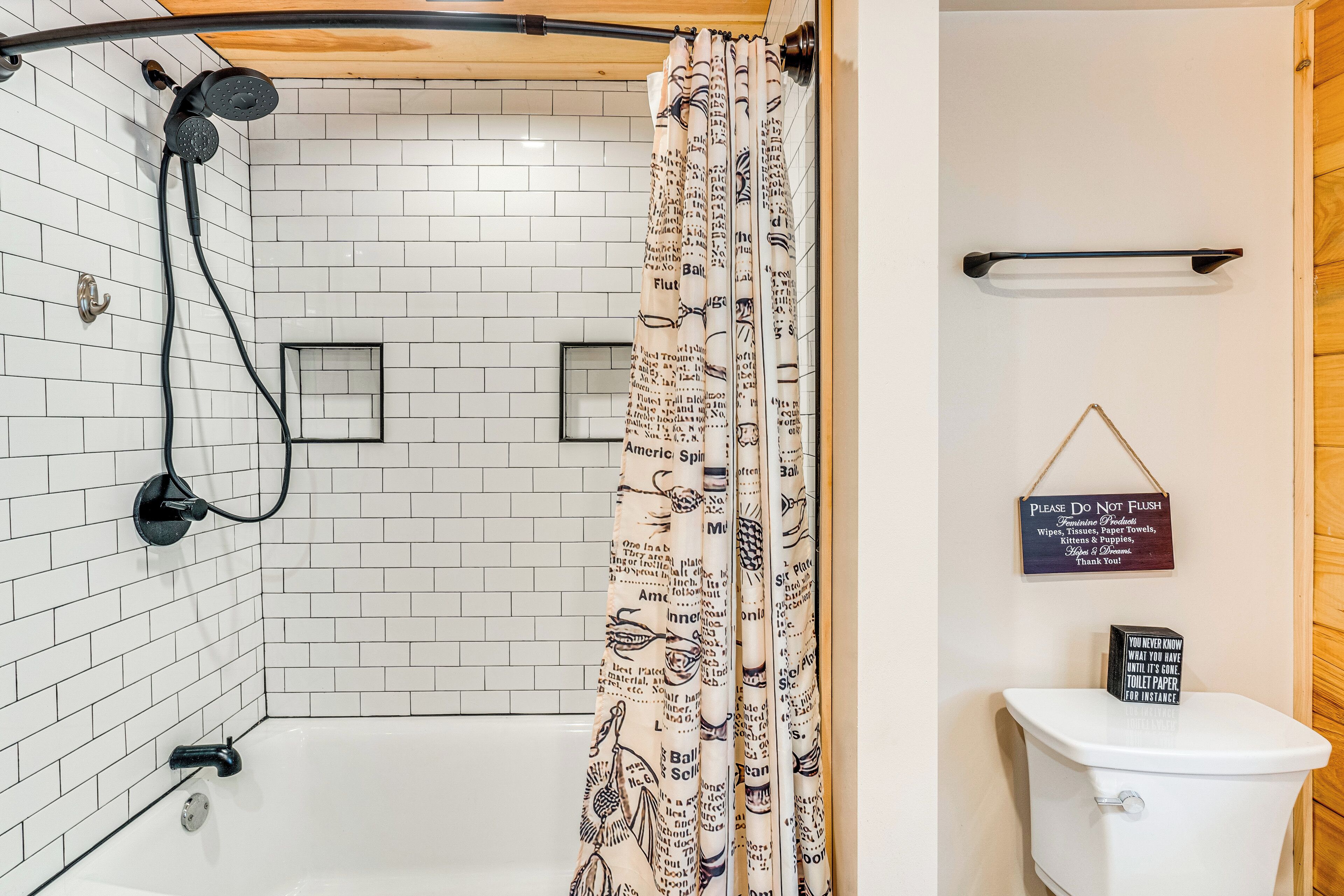 A bathroom with a shower, toilet, and a sign on the wall.