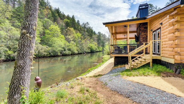 A log cabin with a wooden deck and a staircase leading to a porch overlooking a river. - Relax Fireside! Creek Cabin 9 Mi to Dtwn Murphy (Murphy)