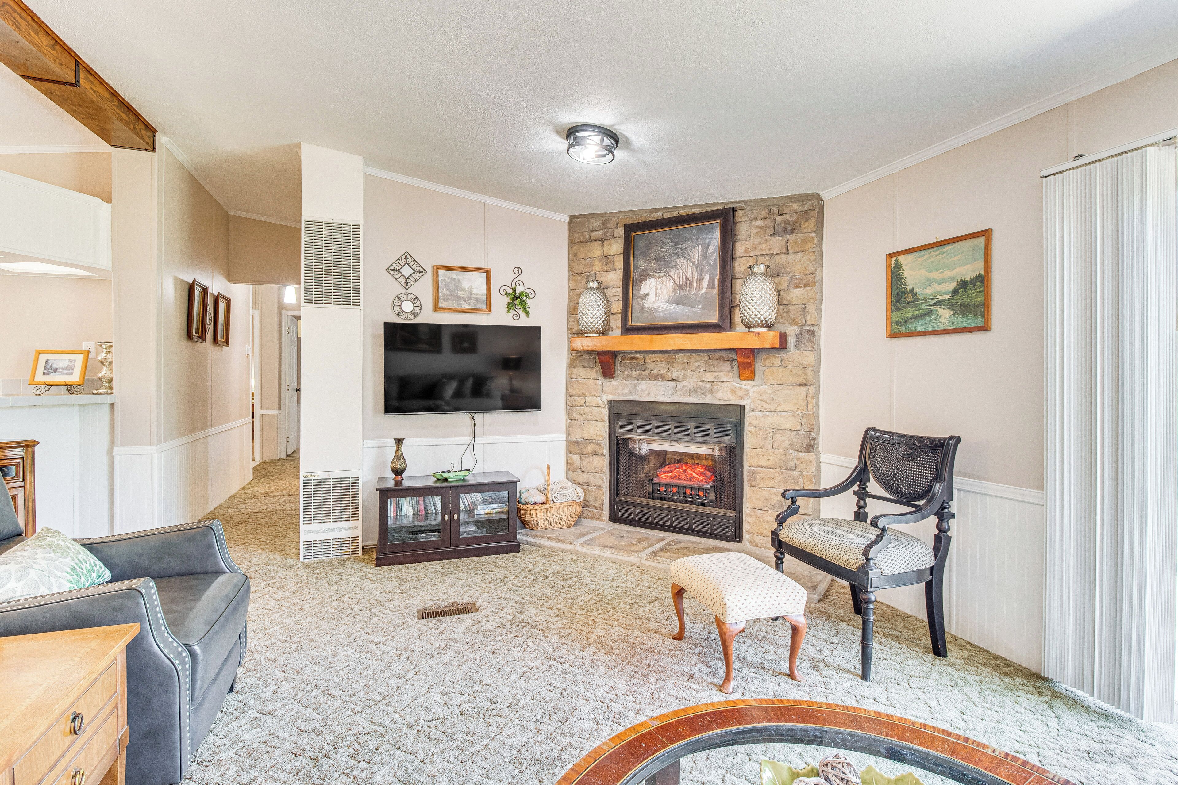 A living room with a fireplace, a television, and a stone accent wall.