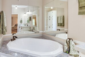 Ein Badezimmer mit einer großzügigen Badewanne, einem Doppelwaschbecken und einer begehbaren Dusche.