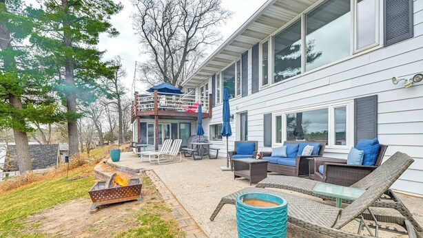 Un espace patio aménagé avec du mobilier d’extérieur, un foyer et un grand bac à plantes.