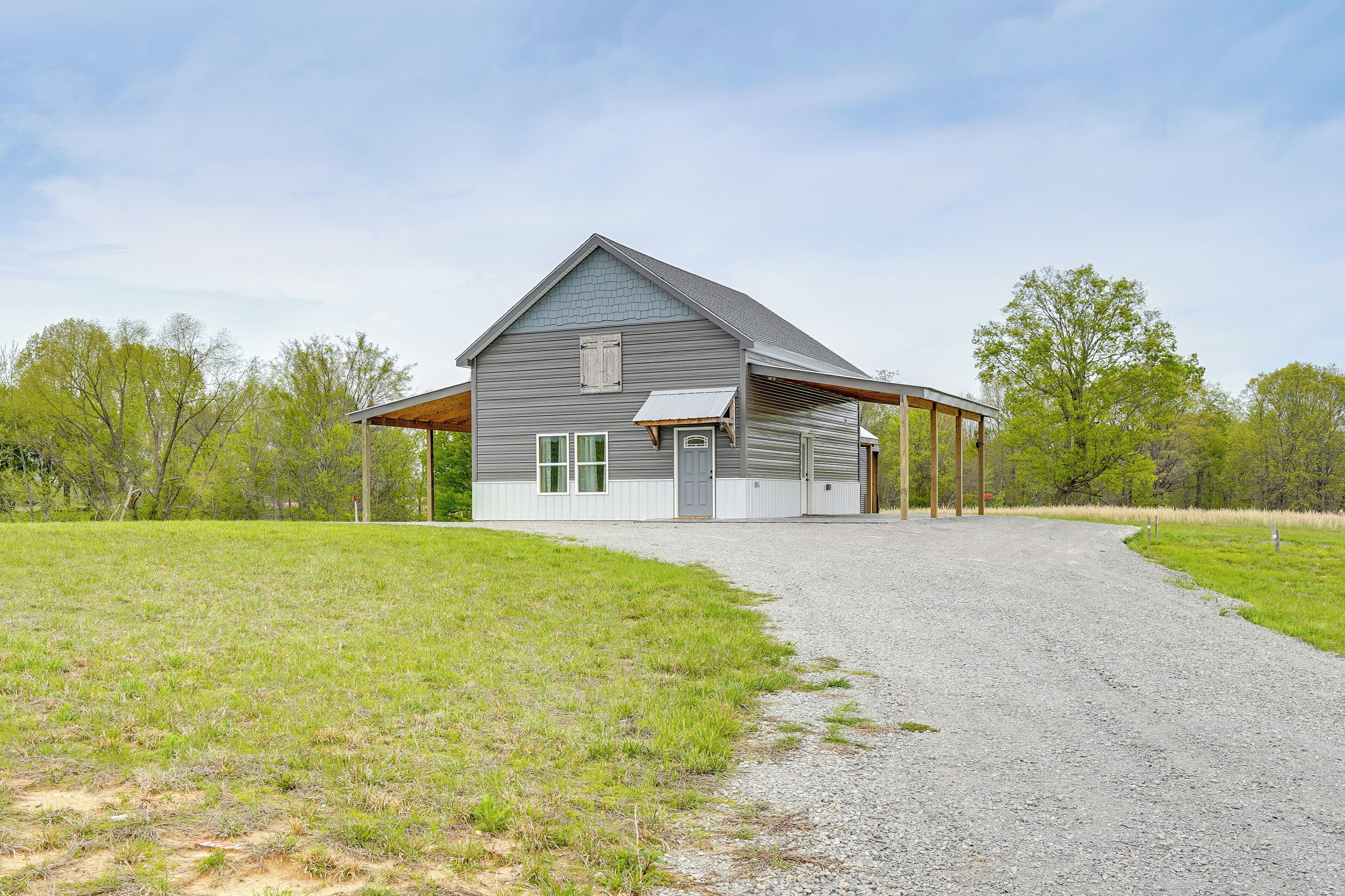 A single-story building with a gabled roof, a covered porch, and a gravel driveway.