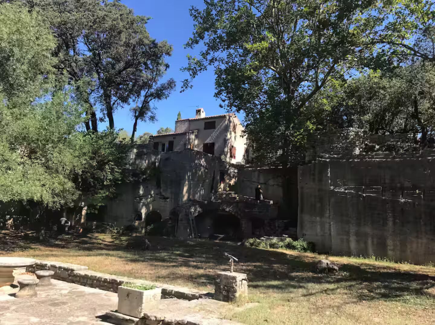 Une ruine antique, avec des murs de pierre et un petit bâtiment.