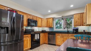 A modern kitchen with wooden cabinets, stainless steel appliances, and a window providing natural light. - Frisco Mountain Retreat- Private Hot Tub (Frisco)