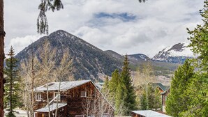 A rustic cabin with a steep roof, surrounded by trees and mountains. - Frisco Mountain Retreat- Private Hot Tub (Frisco)