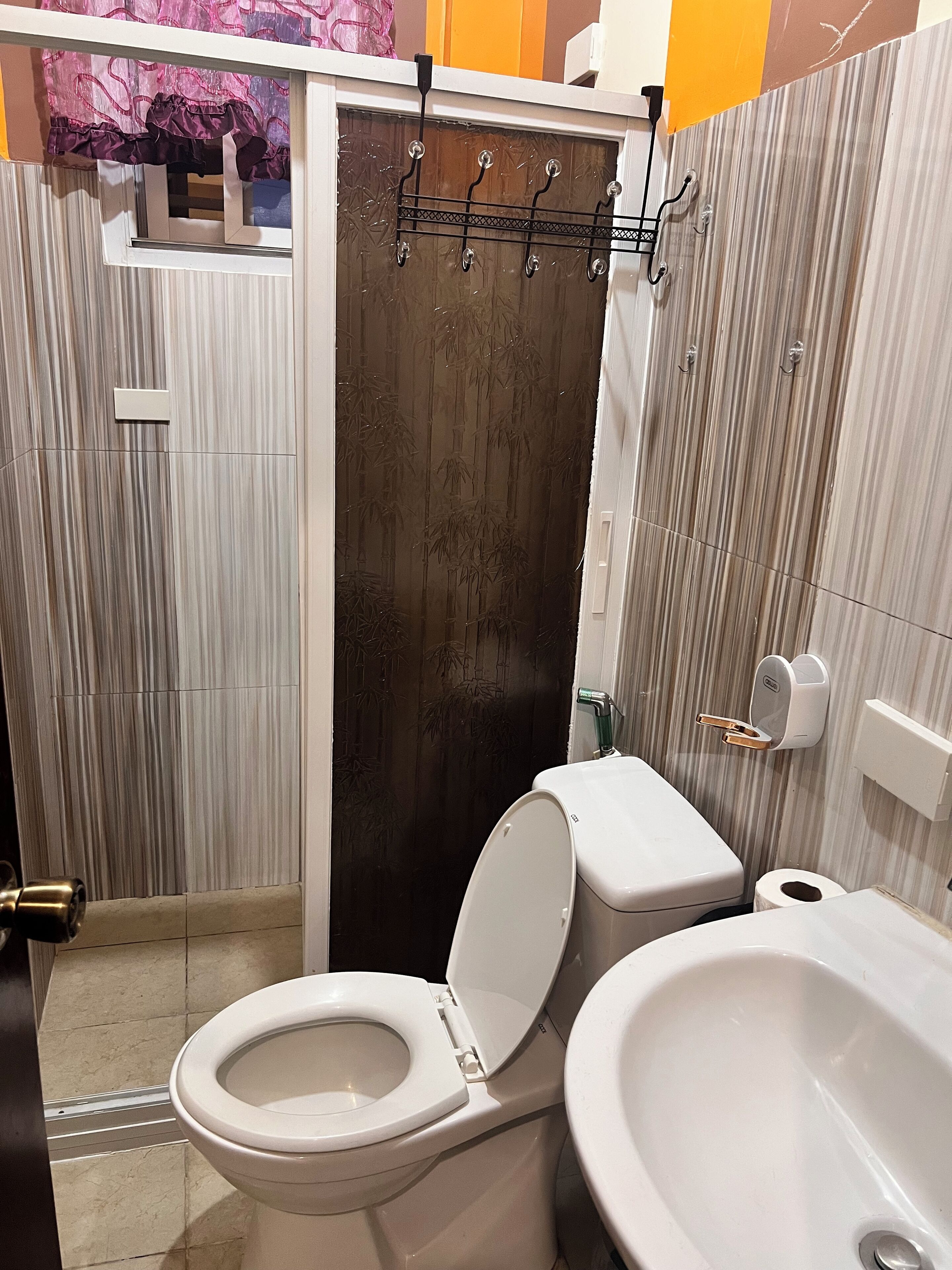 A bathroom with a toilet, bidet, and shower area.