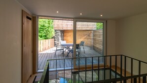 A modern interior with a glass door leading to an outdoor deck area. - Holiday Home in La Roche With Castle Views (La Roche-en-Ardenne)