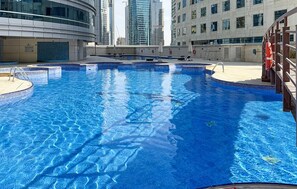 Relax by the rectangular pool surrounded by a wooden deck.