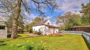 A white house with a tiled roof, a stone wall, and a white picket fence. - The Nook (Goulceby)