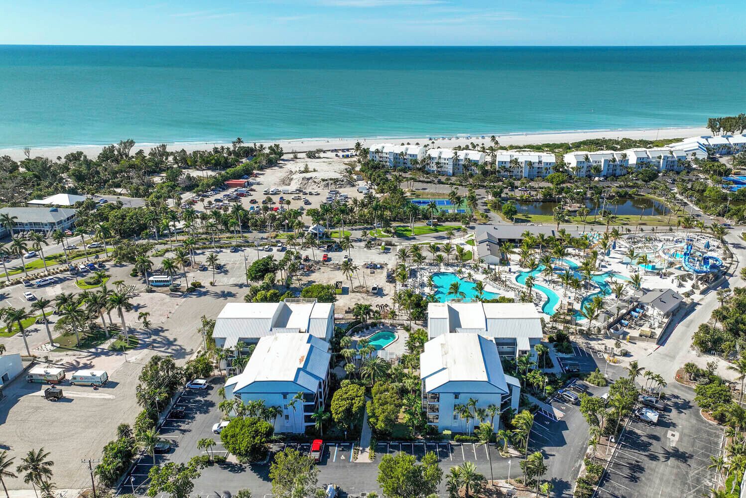 Ein Resort mit mehreren Gebäuden, einem großen Parkplatz und einem Poolkomplex.