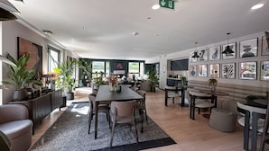 A modern interior with a dining area, seating, and artwork on the walls.