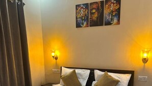 Ein Hotelzimmer mit einem großen Bett, zwei Wandleuchten und drei Bildern an der Wand.