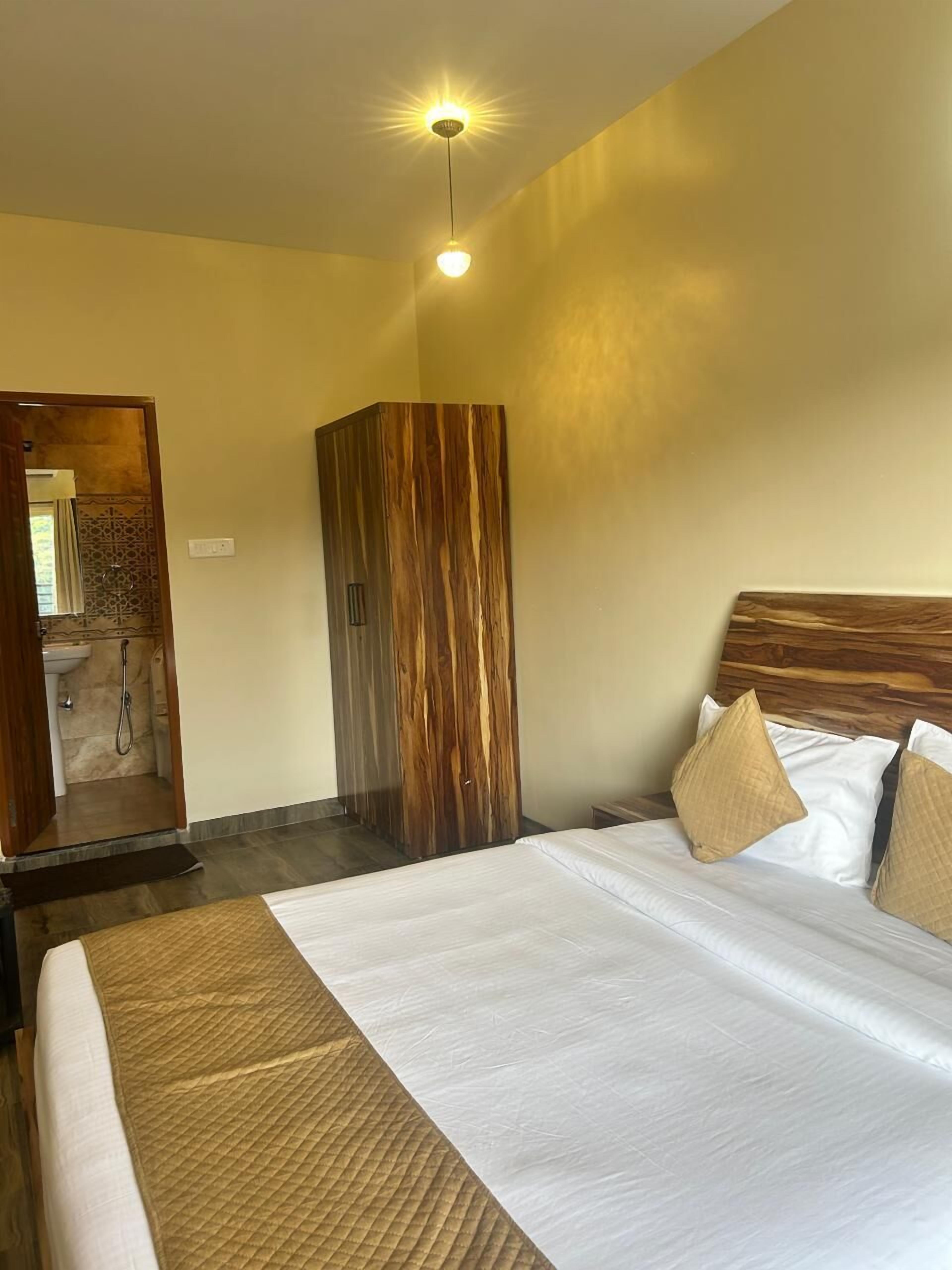 A hotel room with a bed, wooden headboard, and a wardrobe.
